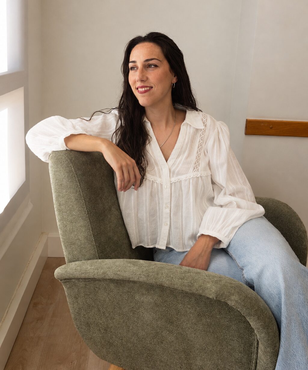 Laia sentada en un sillón junto a la ventana de su consulta